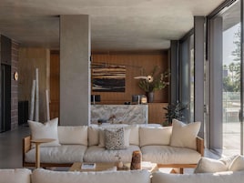 A modern living room with a sofa, coffee table, and a fireplace.