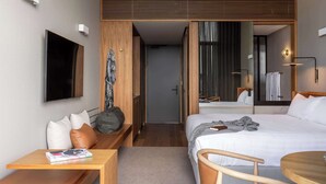 A modern hotel room with a bed, bedside table, chair, and a TV mounted on the wall. - Wonil Hotel Perth - Handwritten Collection (Crawley)