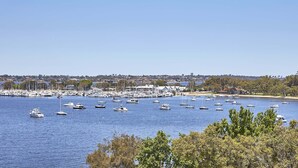 A marina with numerous boats docked, surrounded by trees and a distant cityscape. - Wonil Hotel Perth - Handwritten Collection (Crawley)