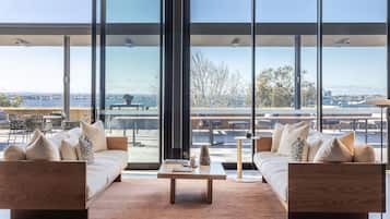 A modern living room with a large window, a sofa set, and a coffee table.
