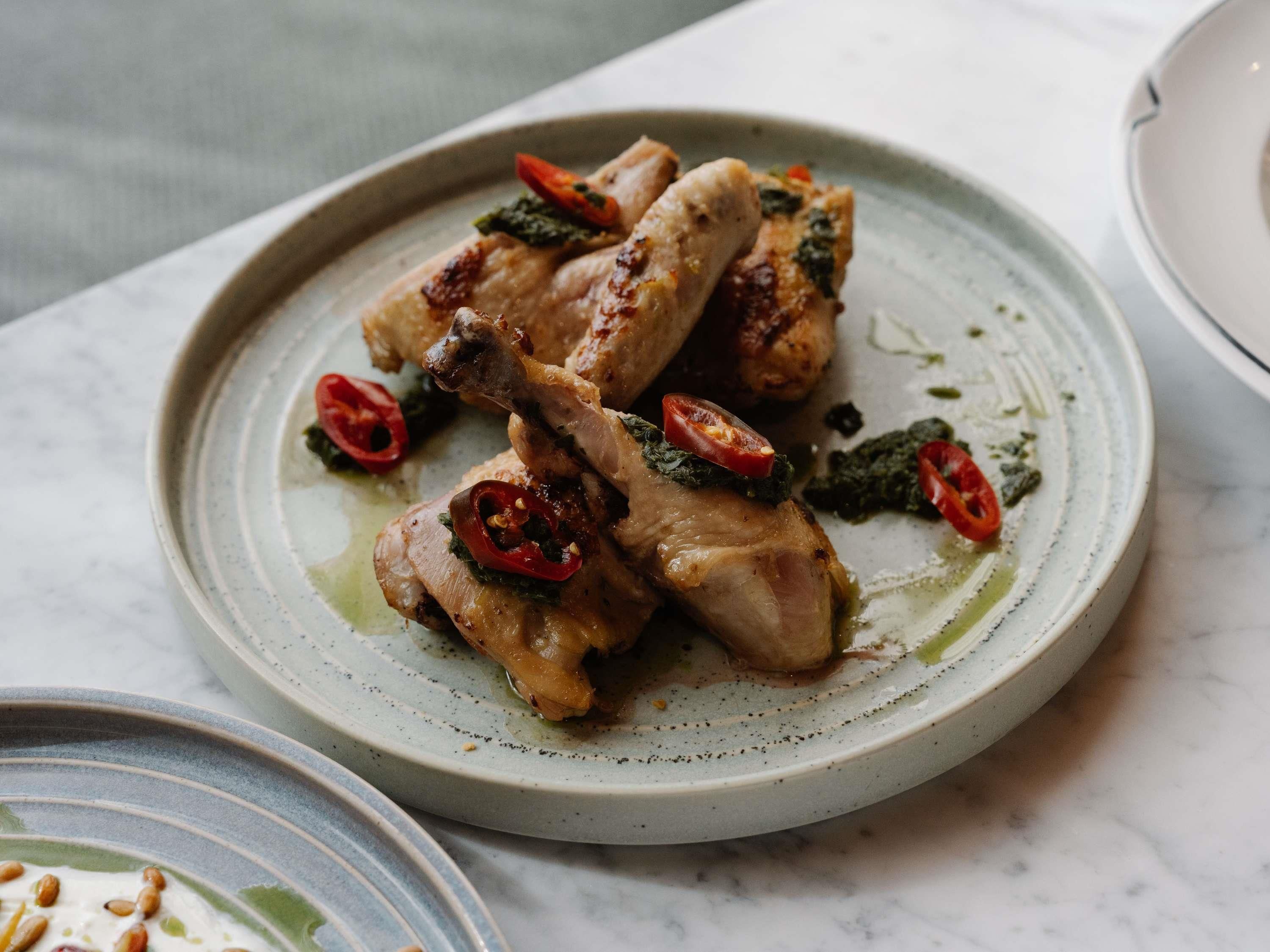 Un plato de comida con pollo y vegetales sobre un plato de cerámica.