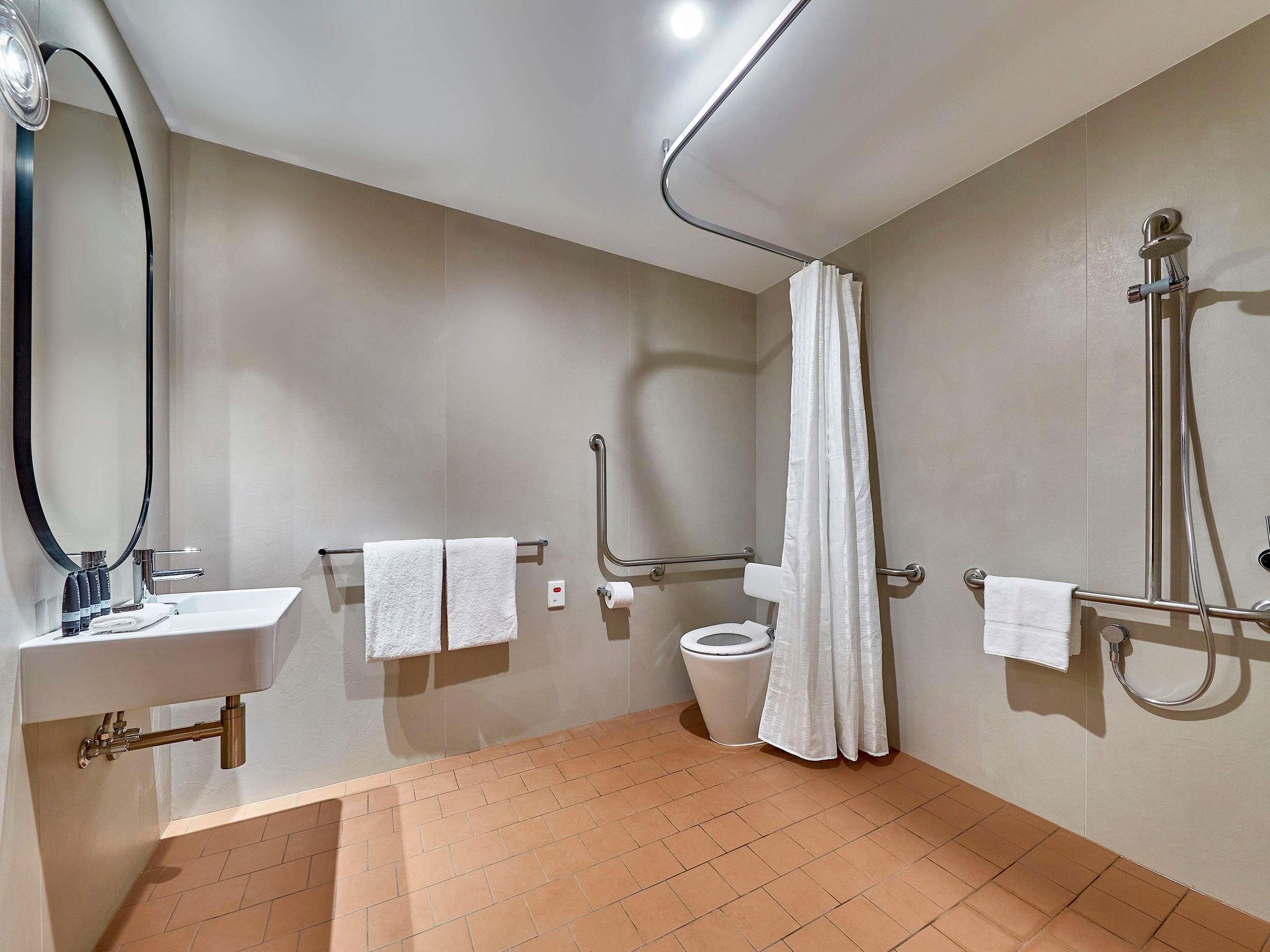 Een moderne badkamer met een wastafel, toilet en douche.