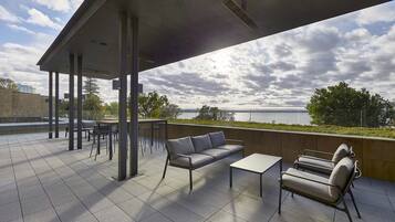 A covered outdoor seating area with a view of the water.