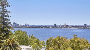 A coastal cityscape with a clear view of the waterfront, including a body of water and a distant city skyline. - Wonil Hotel Perth - Handwritten Collection (Crawley)