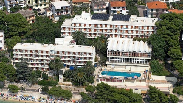 A hotel with multiple balconies, a swimming pool, and a beach area. - Aurora Hotel (Podgora)