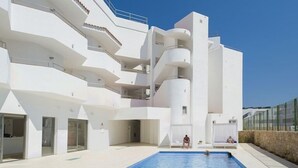 A modern building with a swimming pool, balconies, and a clear sky. - My Way Luxury Ibiza (Sant Josep de sa Talaia)