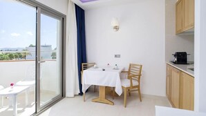 A balcony with a table and chairs, a view of the city, and a kitchenette area. - My Way Luxury Ibiza (Sant Josep de sa Talaia)