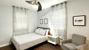 A modern bedroom with a bed, bedside table, chair, and ceiling fan. - Private Spacious 1BR Near LEGOLAND 2 Miles (Winter Haven)