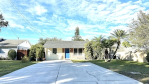 A single-story house with a front porch, a blue door, and a garage. - Private Spacious 1BR Near LEGOLAND 2 Miles (Winter Haven)