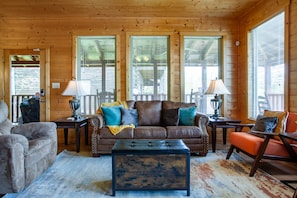 A cozy living room with a brown leather sofa, two armchairs, a coffee table, and a fireplace. - Cozy Mountain Cabin I A++ Views & Amenities (Sevierville)
