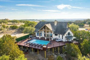 A large house with a swimming pool, deck, and multiple rooms. - Sleeps 20 | Pool, Game Room | Luxury Fall Retreat (Dripping Springs)