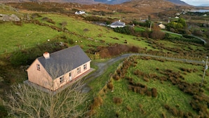 A rural landscape with a house, sheep, and rolling hills. - Cottage 427 - Clifden - sleeps 6 guests  in 3 bedrooms (Clifden)