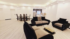 Ein geräumiges Wohnzimmer mit Essbereich, ausgestattet mit einer Sofagarnitur, einem Couchtisch und einem Esstisch mit Stühlen.