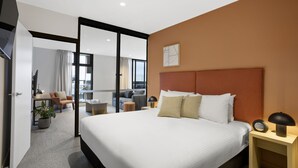 Ein modernes Hotelzimmer mit einem großen Bett, einem Schreibtisch und einer Sitzecke mit Blick.