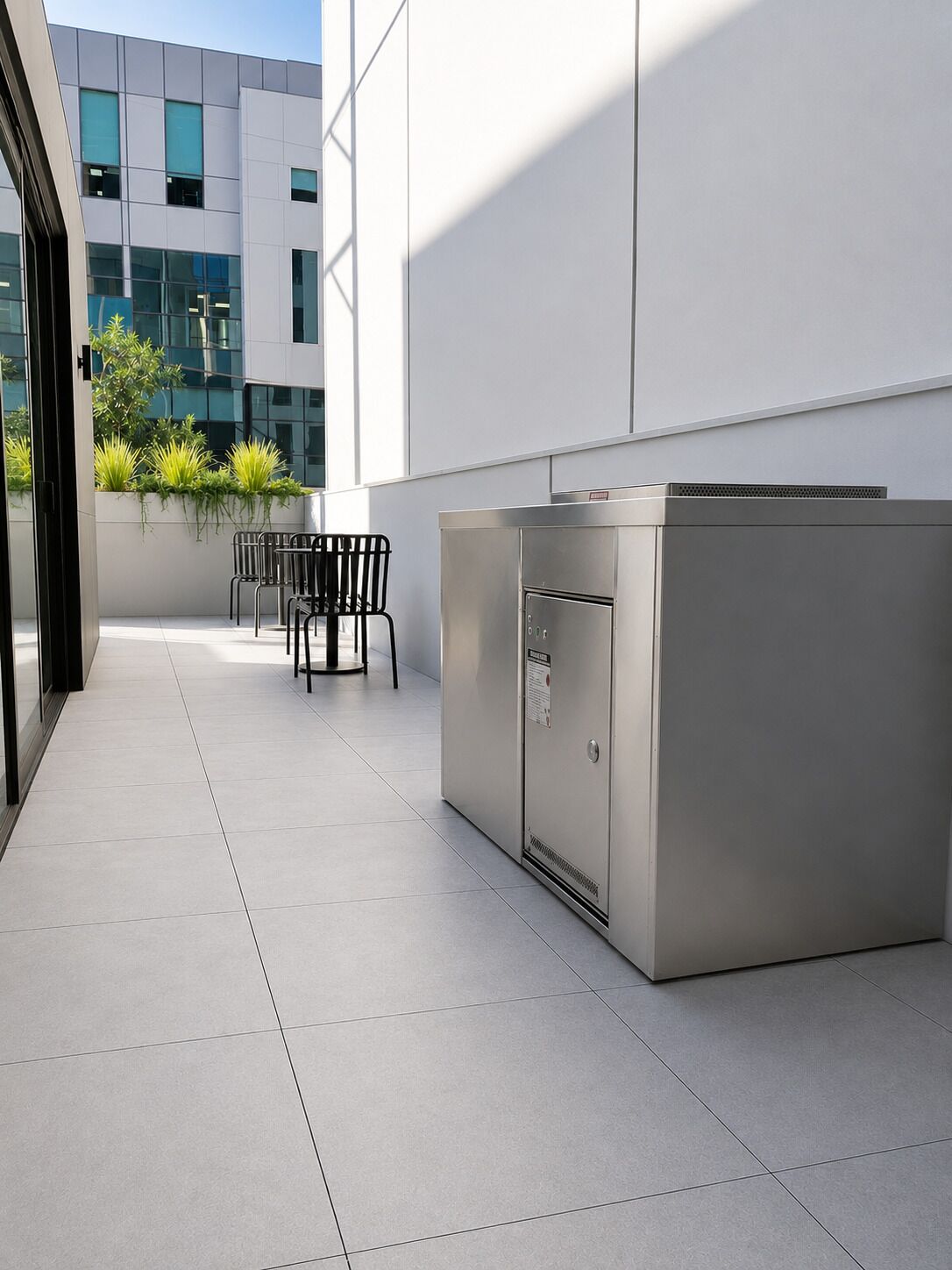 A modern outdoor area with a seating arrangement and a stainless steel appliance.