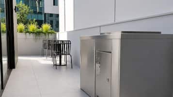 A modern outdoor area with a seating arrangement and a stainless steel appliance.