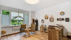 Una sala de estar moderna con comedor, ventanas amplias y vista a zonas verdes.