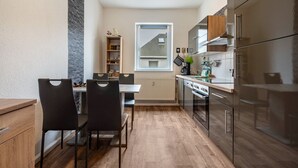 Eine moderne Küche mit Essbereich, Holzschränken und einem Fenster mit Aussicht.