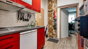 A kitchen with red cabinets, a dishwasher, and a microwave.