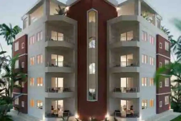 A multi-story hotel with balconies on each floor, a central atrium, and a red accent wall.