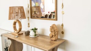 A wooden console table with a mirror, a lamp, and decorative items. - Eclectic, Art-filled Studio with Fantastic Views (El Prado)