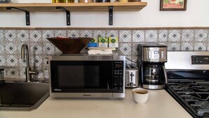 A kitchen with a microwave, coffee maker, and a sink. - Eclectic, Art-filled Studio with Fantastic Views (El Prado)
