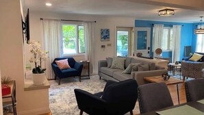 Un salon spacieux comprenant un canapé, des fauteuils et un coin repas.