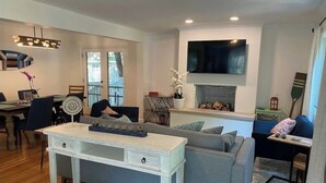 Un salon moderne avec un canapé gris, une table basse blanche et une cheminée.