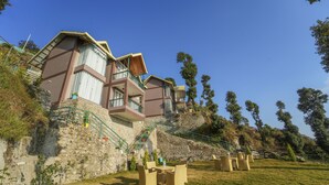 Ein Hotel an einem Hang mit mehreren Balkonen, Außenbereich und einer steinernen Stützmauer.