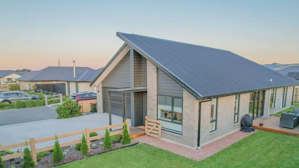 A modern house with a sloped roof, large windows, and a well-maintained lawn. - Warm Safe Quiet Spacious Family Home, Sleeps 7 (Prebbleton)