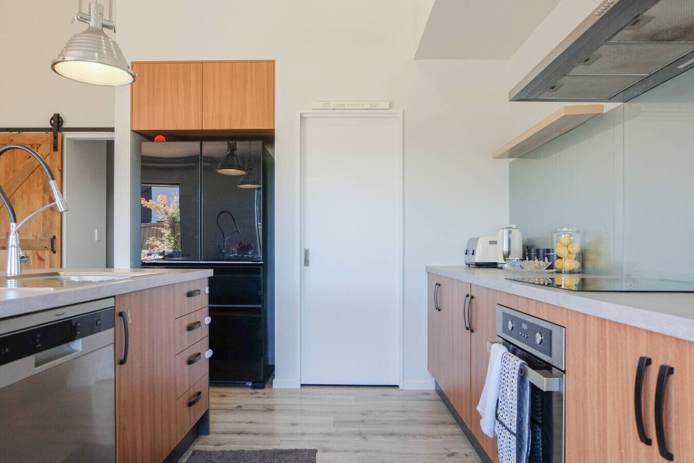 A modern kitchen with wooden cabinets, stainless steel appliances, and a built-in oven.