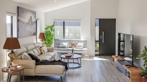 A modern living room with a sofa, coffee table, and TV. - Warm Safe Quiet Spacious Family Home, Sleeps 7 (Prebbleton)