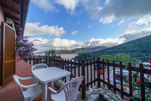 A balcony with a table and chairs, overlooking a scenic view of a lake and mountains. - APP.TI LA PAOLINA NUOVI - LA PAOLINA 13 (Marciana)