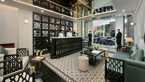 Eine Hotelhalle mit Empfangstresen, Sitzgelegenheiten und dekorativen Wandpaneelen.