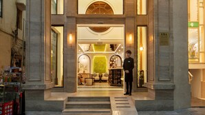 Der Eingang zum Hotel Derond mit einem imposanten Bogen und einem hell erleuchteten Innenbereich, der durch die Türen sichtbar ist.