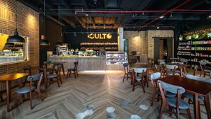 A restaurant interior with a bar area, hexagonal patterned floor, and a sign that reads "CULTO". - Morph Chico (Bogotá)