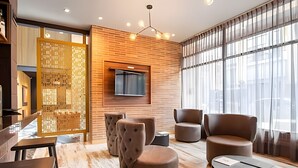 A modern lounge area with a wooden wall, a flat-screen TV, and comfortable seating. - Morph Chico (Bogotá)