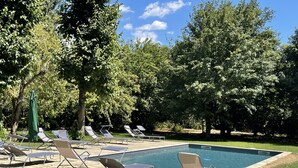 Ein Poolbereich mit Liegestühlen und Schwimmbecken.