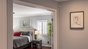 A bedroom with a bed, bedside table, lamp, and artwork on the wall. - 20% Disc-Modern-King Bed, Jacuzzi, Fire Pit, BBQ+ (Los Angeles)