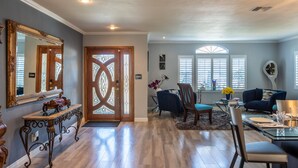 A spacious living room with a large mirror, a dining area with a glass table, and a cozy seating arrangement. - 20% Disc-Modern-King Bed, Jacuzzi, Fire Pit, BBQ+ (Los Angeles)