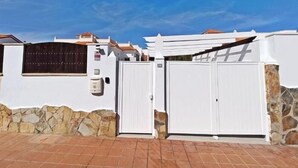 A white building with a stone foundation and a tiled roof.