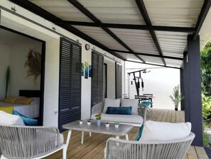 Relax in a serene outdoor space with a wooden deck, wicker furniture, and a table for al fresco dining.