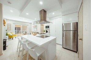 A modern kitchen with a central island, stainless steel appliances, and a bright, open layout. - Luxury 2BR Condo w/ Balcony | Aracari 18 by Bocobay (Noord)