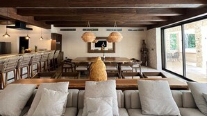 Ein modernes Interieur mit einer großen Couch, Essbereich und Küche.