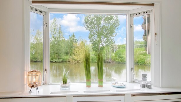 A room with a large window overlooking a body of water and greenery. - Water Villa in Ooltgensplaat Near Volkerak (Ooltgensplaat)