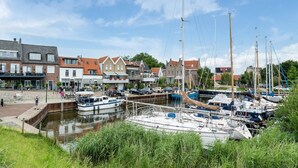A marina with several sailboats docked, surrounded by traditional European-style buildings. - Idyllic Holiday Home in Ooltgensplaat on the Water (Ooltgensplaat)