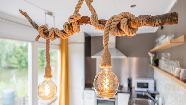 A modern kitchen with a hanging light fixture made of rope and glass bulbs. - Idyllic Holiday Home in Ooltgensplaat on the Water (Ooltgensplaat)