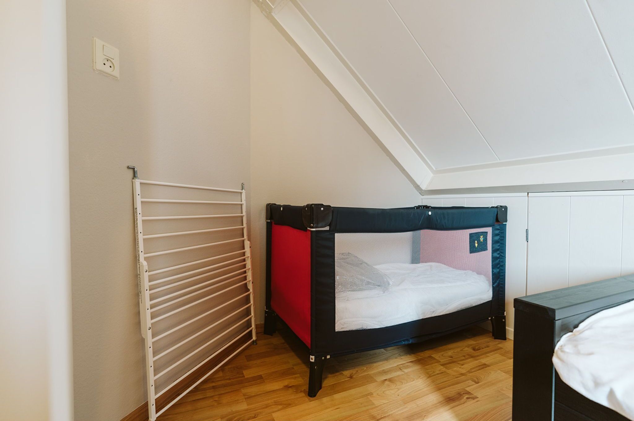 Une chambre de type dortoir, avec des lits superposés, un radiateur blanc et un plancher en bois.