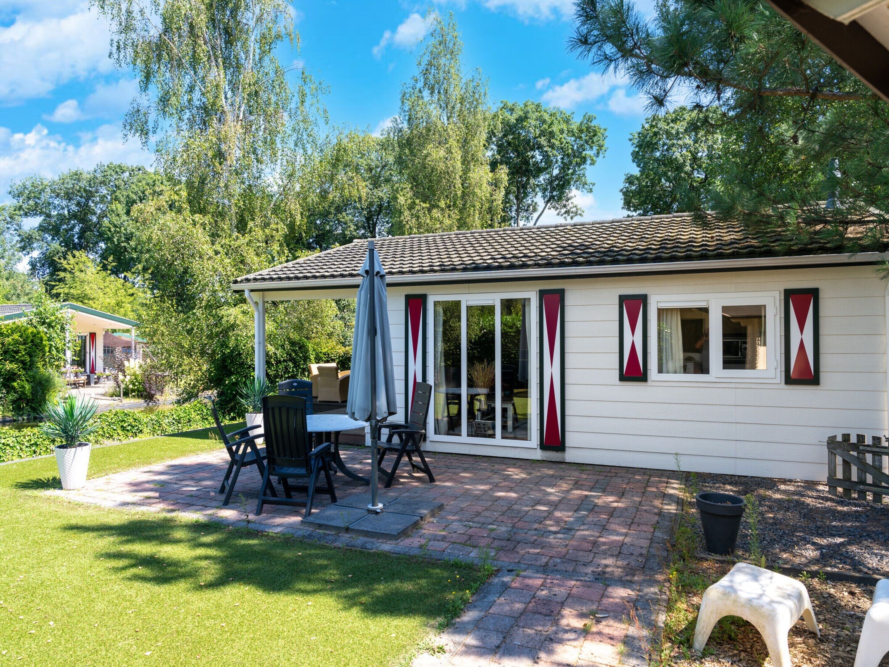 A house with a patio, outdoor furniture, and a covered seating area.