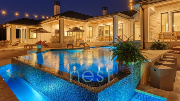 A modern house with a swimming pool, outdoor seating, and a stone facade. - ***NEW*** INFINITY POOL | HOT TUB | Views | Pool Table | Fire Pit | 16 Queen Beds (Austin)